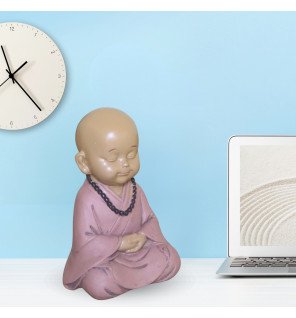  statue bébé bouddha installée près d’une plante verte pour une touche naturelle et relaxante