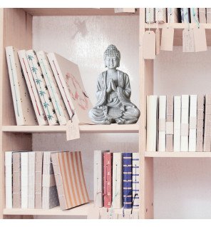  décoration zen avec une statue bouddha grise sur un meuble en bois clair