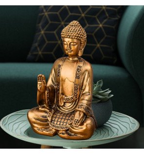  ambiance zen dans un salon avec la statue dorée placée près de plantes vertes