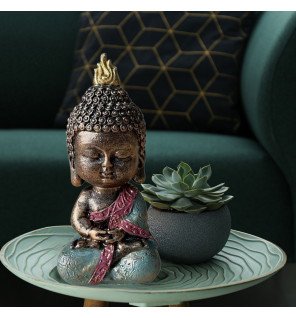  statue décorative bébé bodhi en résine verte sur une table basse