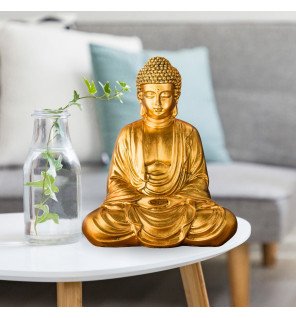  statue de méditation dorée capturant la lumière naturelle d’une fenêtre