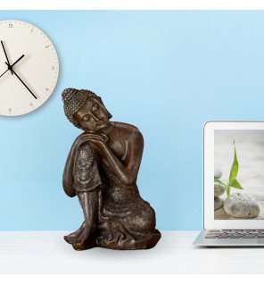  ambiance tamisée avec la statue bouddha penseur au centre d’un espace de détente