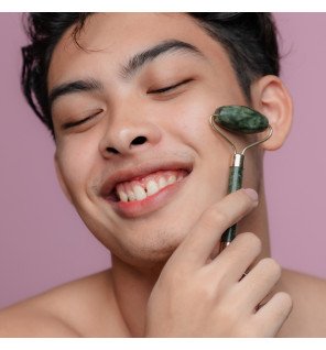 accessoires de massage en pierre de jade vert utilisés lors d’une routine de soin du soir