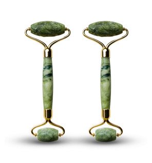 rouleaux masseur en jade vert entourés de produits cosmétiques naturels et d’huiles essentielles