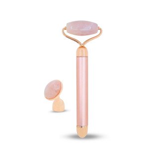 masseur visage électrique en quartz rose entouré de produits de soin pour une routine beauté complète