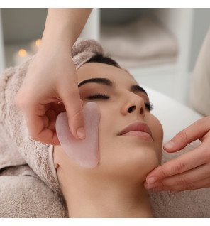 accessoire en pierre de quartz rose à côté d’un flacon d’huile cosmétique