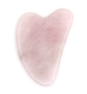 gua sha sun&sia en quartz rose mis en scène dans un décor zen et apaisant