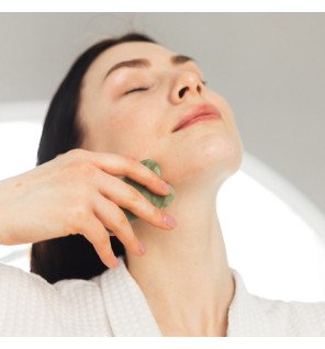 accessoire bien-être en pierre de jade sur fond neutre pour soin du visage