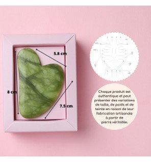 outil de soin du visage en jade vert sur une serviette moelleuse