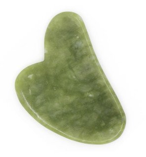 pierre de jade pour massage facial utilisée dans une routine beauté du soir