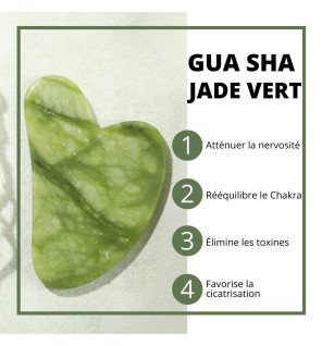 outil de massage traditionnel en jade vert sur une table en bois clair