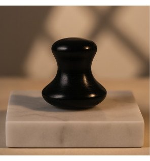 champi gua sha en serpentine de la marque sun&sia posé sur une table en bois