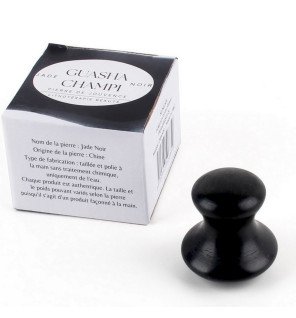 gua sha en serpentine présenté avec d’autres accessoires de massage traditionnels