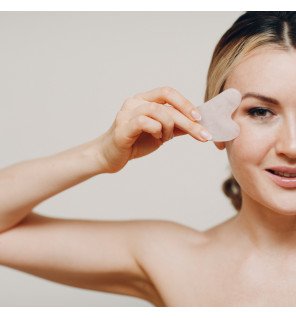 accessoire beauté gua sha en pierre claire utilisé pour le soin du visage