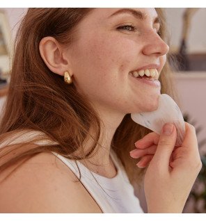 outil de soin visage gua sha en pierre naturelle sur une table de salle de bain