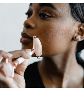 accessoire de massage pour le visage sur un plateau en marbre avec fleurs séchées