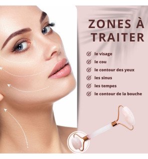 masseur facial en quartz rose à côté d’un miroir rond et de produits cosmétiques