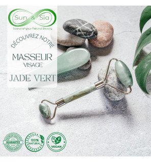 roller en jade vert à côté d’un pot de crème hydratante sur une table de salle de bain