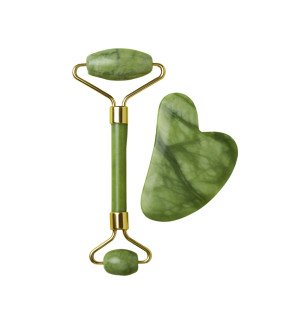 main féminine tenant le gua sha en jade vert prête à masser le contour du visage