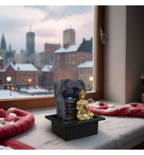  fontaine zen avec bouddha assis et éclairage doux créant une ambiance relaxante