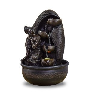  fontaine bouddha krishna installée sur une étagère avec des accessoires de bien-être et bougies