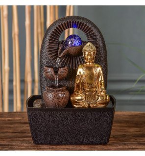  fontaine bouddha installée près de plantes vertes pour une atmosphère naturelle