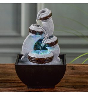  mise en scène de la fontaine kara sur une étagère entourée de plantes vertes