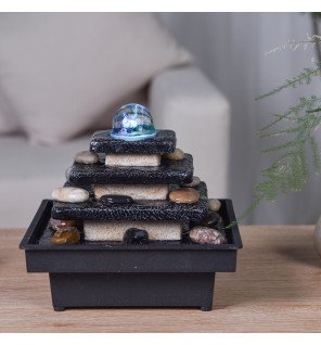  fontaine d'intérieur en fonctionnement avec reflets lumineux sur l'eau