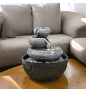  ambiance tamisée créée par la fontaine zen avec reflets lumineux sur l'eau