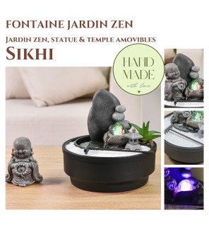  vue rapprochée de la statuette bouddha intégrée à la fontaine et entourée de sable blanc