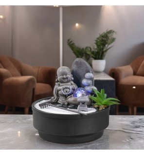  fontaine d'intérieur en fonctionnement avec reflets de lumière sur l'eau et les pierres décoratives