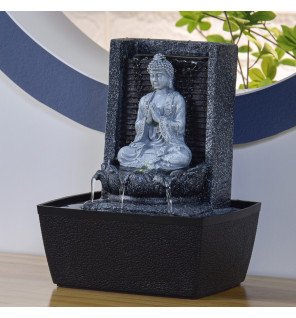  fontaine zen placée sur une étagère avec des plantes vertes autour
