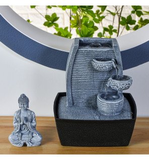  fontaine bouddha sagesse placée sur une étagère avec des objets de décoration