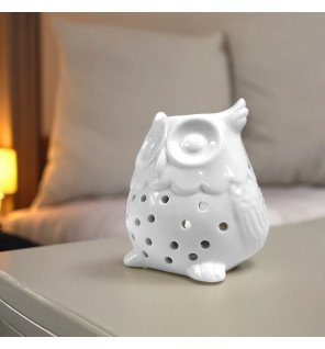  brûle-parfum hibou en céramique blanche sur une table de chevet pour parfumer la chambre