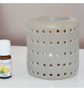  brûle-parfum gris coliseo utilisé lors d’une séance de relaxation avec des coussins et des plantes