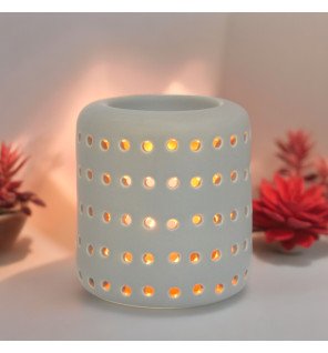  brûle-parfum coliseo gris utilisé pour parfumer une chambre à coucher cosy