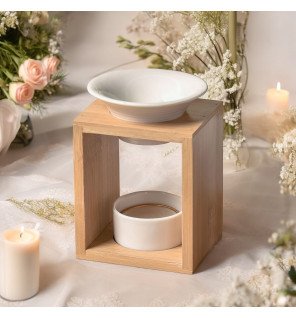  arina brûle-parfum en céramique blanche associé à des accessoires de bien-être sur une table basse