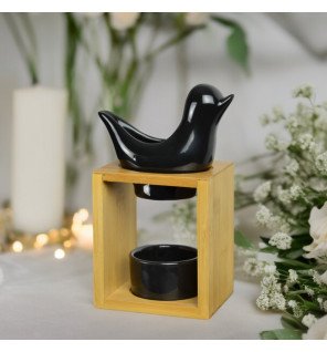  main versant quelques gouttes d’huile essentielle dans le brûle-parfum birdy noir