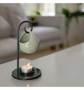  détail du brûle-parfum montrant la texture lisse de la céramique blanche et le support en métal noir