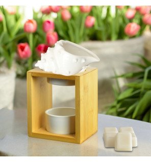  gros plan sur le brûle-parfum shell avec une bougie allumée et lumière tamisée