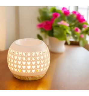  détail de la lumière tamisée passant à travers les motifs cœur du brûle-parfum