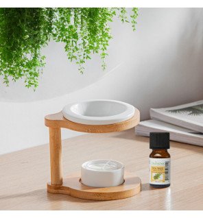  ambiance cocooning avec le brûle-parfum posé près de coussins et d’une plante verte