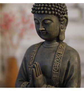  statue bouddha assise en méditation sur une étagère en bois clair