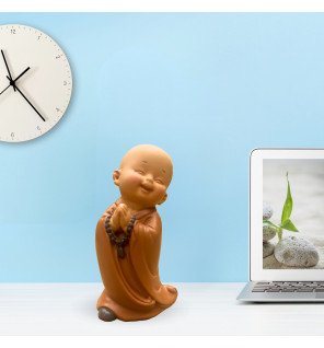  figurine bébé bonze tenant des chapelets délicats sur un coussin moelleux