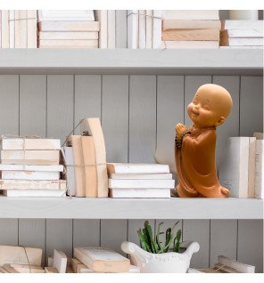  ambiance zen avec la statue bébé bonze placée près d’une bougie allumée