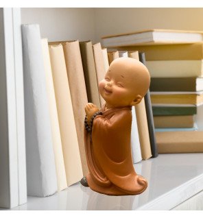  mise en scène cocooning avec la statue bébé bonze à côté d’un livre ouvert