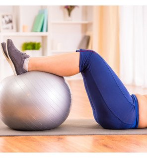  ballon de yoga élégant couleur argent placé à côté d’un tapis et d’une gourde