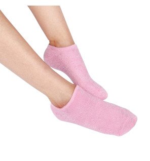  chaussettes roses pour spa prêtes à l’emploi sur un lit avec peignoir et fleurs de coton