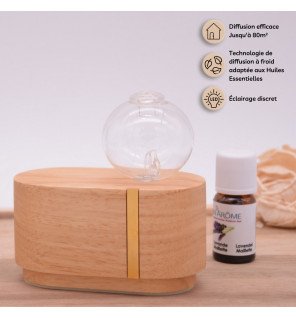  diffuseur par nébulisation avec huiles essentielles à côté d’un livre et d’une tasse de thé