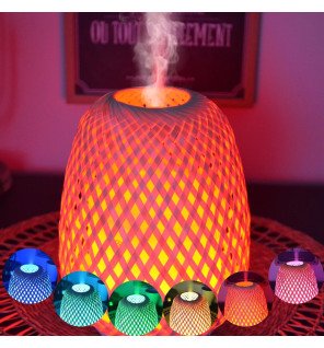  ambiance zen avec le diffuseur olaki posé près de plantes vertes et d'une bougie allumée